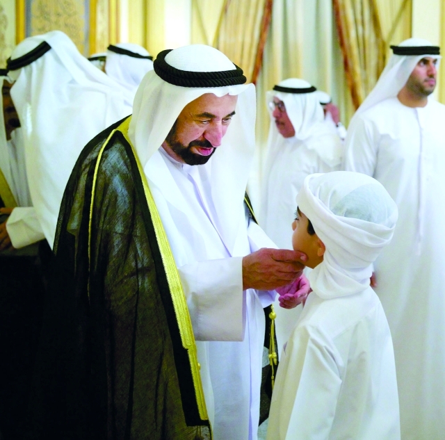 "سلطان القاسمي في حديث أبوي مع أحد الأطفال المهنئين"