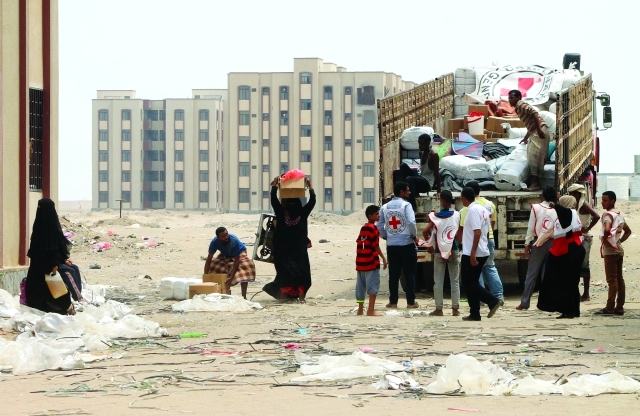 "■ يمنيون يتلقون مساعدات من الهلال الأحمر في عدن | أ.ف.ب"