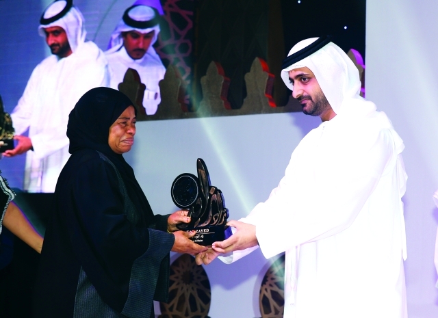 "■ والدة الشهيد هزيم عبيد خلفان آل علي تتسلم درع التكريم عن فئة «زاد الوطن»"