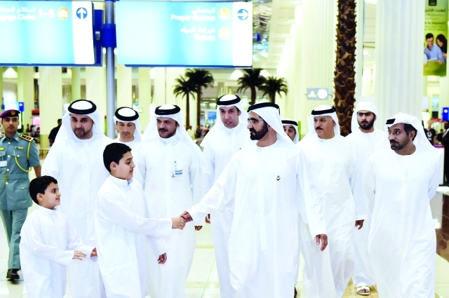 "محمد بن راشد مصافحاً أحد الأطفال خلال جولته في مطار دبي أمس بحضور أحمد بن سعيد وخليفة سليمان وخليفة الزفين وعبيد بن مهير والسبوسي وطلال الشنقيطي | تصوير محمد هشام"