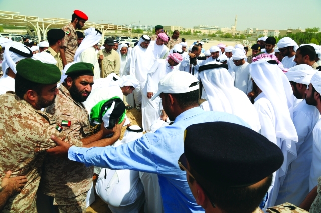 "رفاق السلاح يحملون العلم الذي لف جثمان الشهيد"