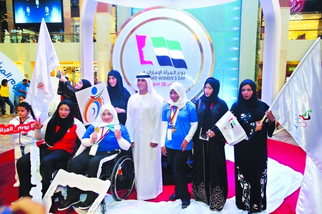 "■ سالم القاسمي يتوسط مجموعة من اللاعبات الإماراتيات بعد الكشف عن شعار يوم المرأة الإماراتية | تصوير – عمران خالد"