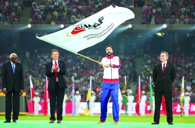 "■ العداء البريطاني روني يلوح بعلم الاتحاد الدولي للقوى إيذاناً باستضافة لندن مونديال 2017 ا ف ب"