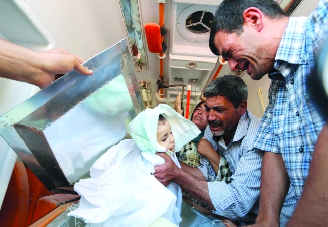 "الوالد عبد الله شنو يبكي بالقرب من جثة ابنه أيلان (أي بي ايه)"