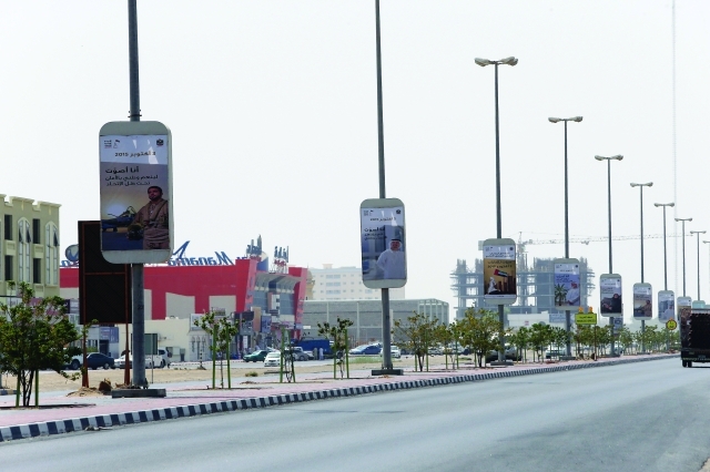 "تصوير الدعايات الإعلانية لمرشحي المجلس الوطني في أم القيوين على طول شارعي الملك فيصل ــ تصوير: غلام كاركر"