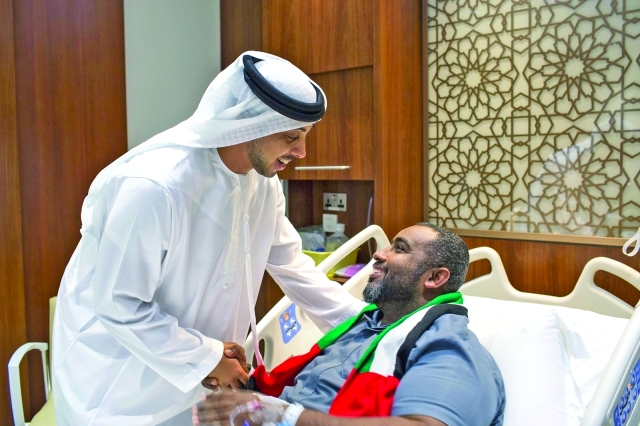 "■ منصور بن زايد مصافحاً أحد الجرحى"