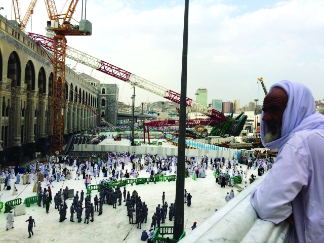 "حاج يتأمل الباحة الشرقية للحرم المكي حيث تبدو الرافعة التي تسببت بالحادث | أ.ف.ب"