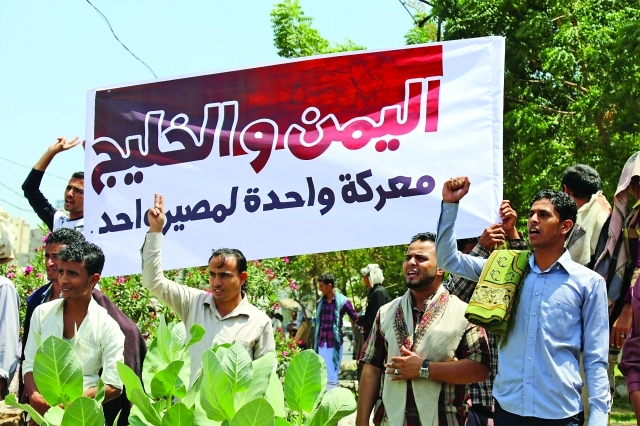"يمنيون في تعز يحملون لافتة تشكر دول الخليج لدعم الشرعية | أ.ف.ب"
