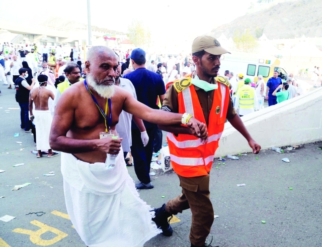 "عنصر أمن سعودي يساعد أحد الحجاج  /   البيان"
