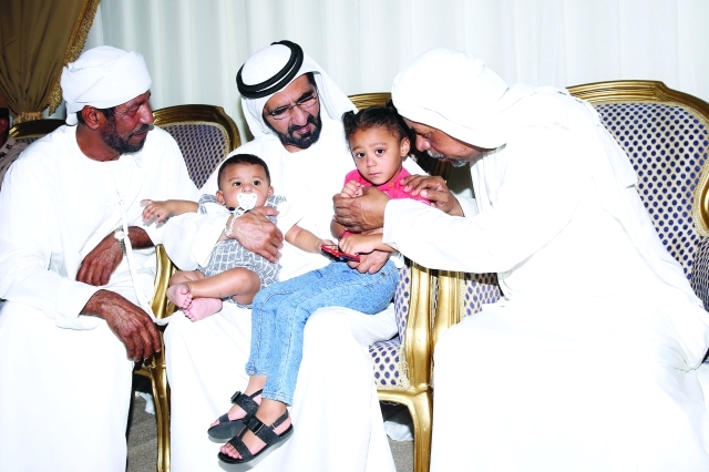 "■ محمد بن راشد محتضناً ابني الشهيد يوسف الكعبي | البيان"