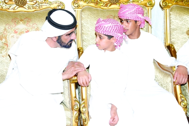 "محمد بن راشد خلال العزاء مع ابني الشهيد محمد السيابي"