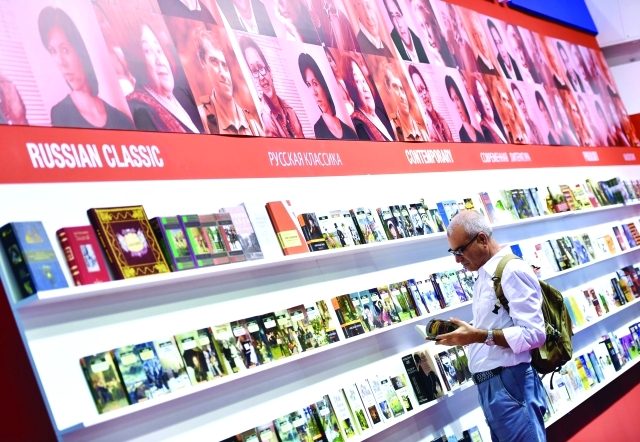 "قارىء يتصفح كتاباً في أحد أجنحة معرض فرانكفورت | إي بي إيه"