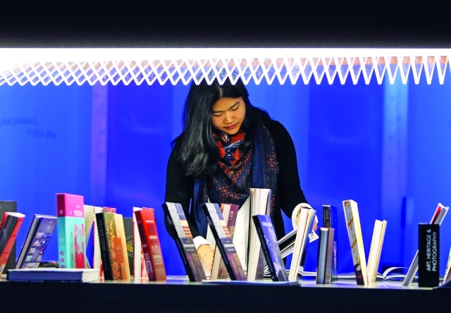 "قارئة تتصفح كتباً في تظاهرة فرانكفورت الثقافية ــ إ ف ب"