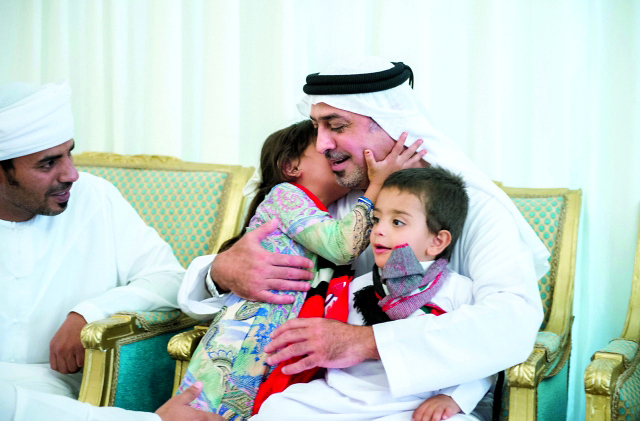 "■ سلطان بن خليفة محتضناً ابني الشهيد حمود العامري"