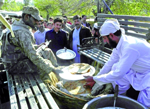 "■ جنود باكستانيون يوزعون المواد الغذائية للناجين من الزلزال | أ.ف.ب"