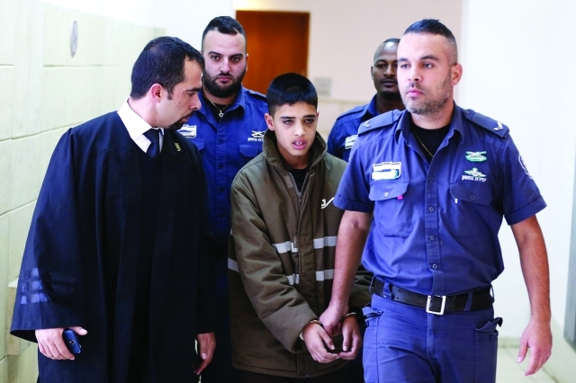 "Ⅶ أفراد من شرطة الاحتلال يأخذون الطفل مناصرة للمحكمة | أ.ف.ب"