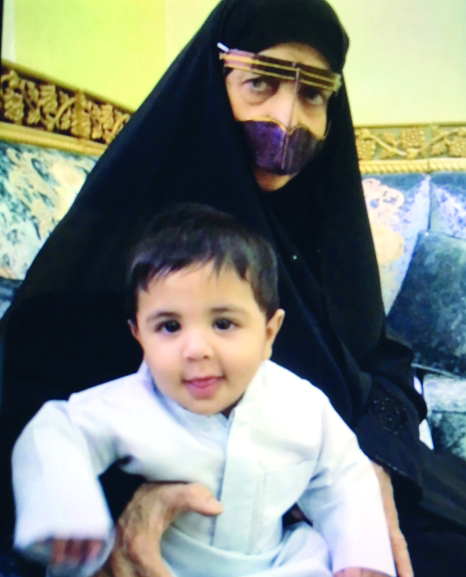 "■ والدة الشهيد تحتضن حفيدها حشر"