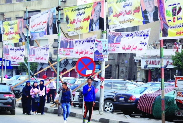 "■ مصريون يسيرون تحت لافتات الدعاية الانتخابية في القاهرة | إي.بي.إيه"