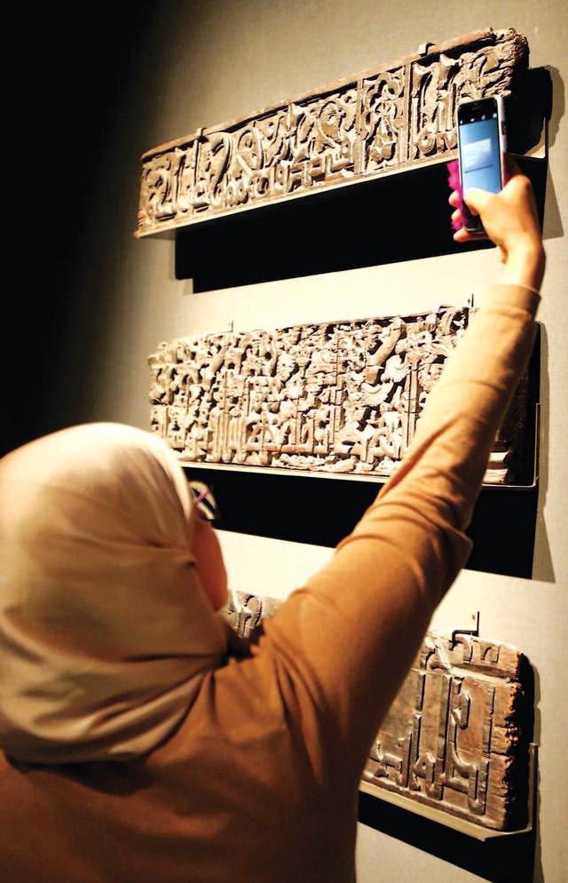 "زائرة تلتقط صورة لأحد المعروضات"