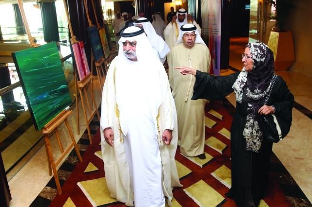 "نهيان بن مبارك يستمع إلى شرح نجاة مكي بحضور الصايغ عن لوحاتها في المعرض المصاحب | البيان"