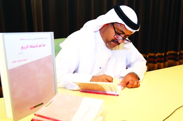 "■ عبيد خلال توقيعه ديوانه"