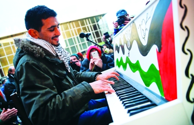 "■ اللاجئ الفلسطيني من سوريا أيهم أحمد الفائز بجائزة بيتهوفن يعزف في التظاهرة | رويترز"