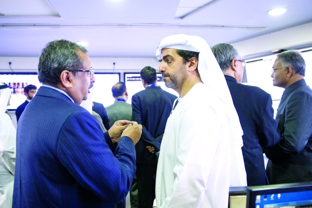 "■ حامد بن زايد خلال الحديث مع أحد مسؤولي السوق"