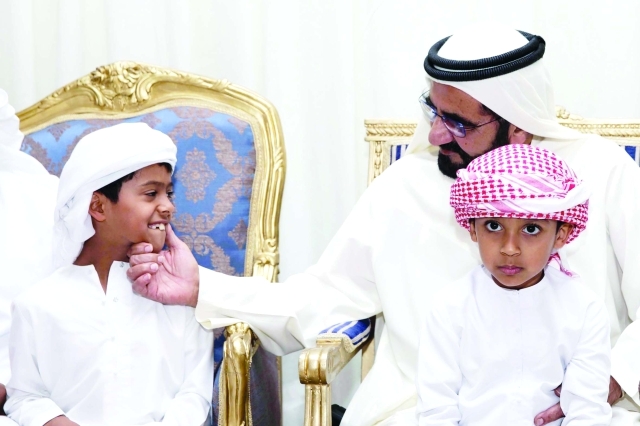 "محمد بن راشد مع طفلي الشهيد زايد الكعبي"
