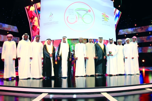 "■ منصور بن زايد يتوسط أسرة اتحاد الدراجات خلال حفل التكريم بحضور نهيان بن مبارك | البيان"