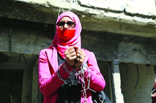 "■ سيدة من تعز تقيد يديها في احتجاج رمزي على الحصار الحوثي للمدينة | ارشيفية"