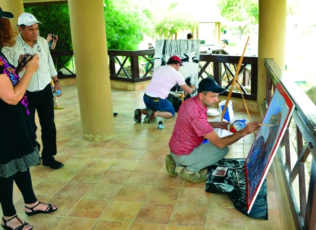 "■ فنانان خلال رسم اللوحتين من وحي أجواء حديقة العين"