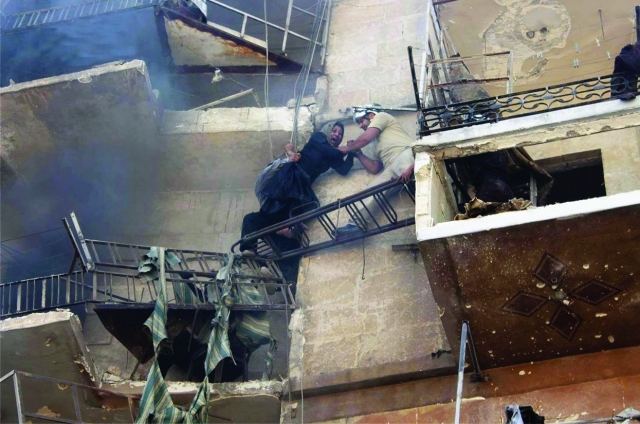 "■ صورة بثها ناشطون لامرأة تحاول الانتقال من نافذة شقة تعرضت لقصف النظام إلى أخرى في حلب | البيان"