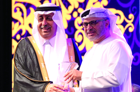 "■ بندر بن سعود يتلقى درع التكريم من قرقاش"