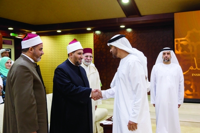 "محمد بن زايد محيياً العلماء الضيوف خلال المحاضرة"