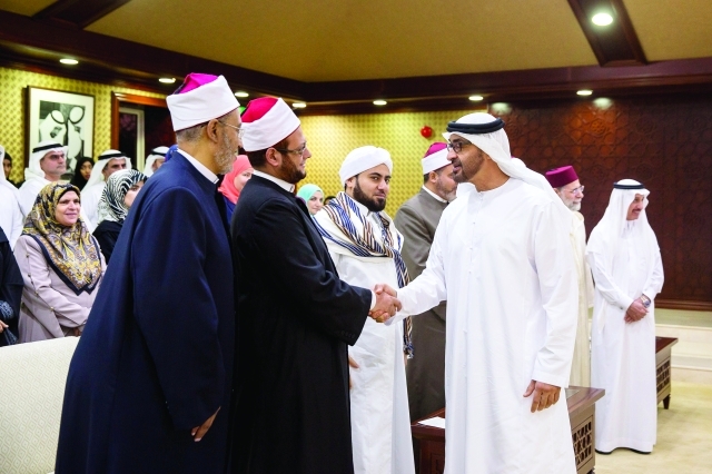 "■ محمد بن زايد مصافحاً العلماء الضيوف بحضور محمد الكعبي"