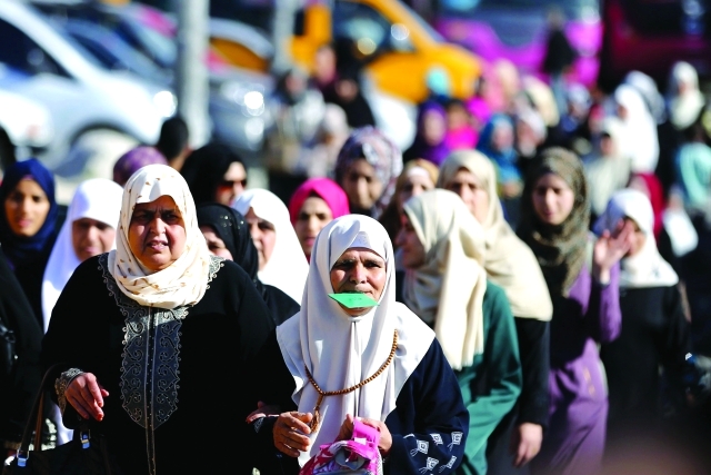 "فلسطينيات ينتظرن عبور حاجز قلنديا في طريقهن للحاق بالصلاة أ.ف.ب"
