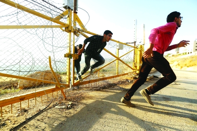 "■ صبية فلسطينيون يقتحمون ويمزّقون الأسلاك الشائكة لأداء الصلاة | إي.بي.ايه"