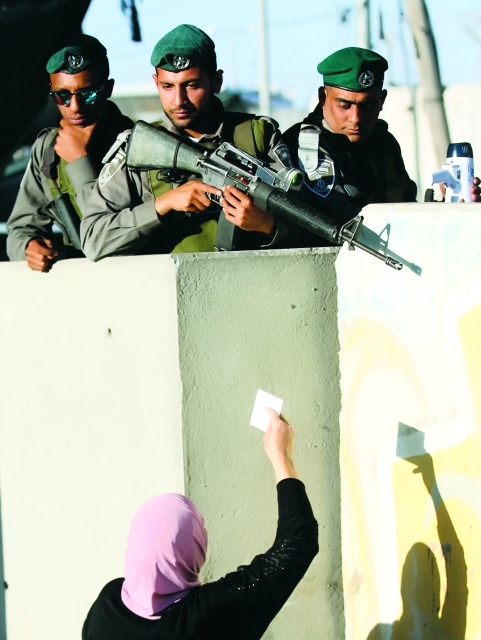 "■ سلاح الاحتلال موجّه إلى الفلسطينيين لدى محاولتهم عبور حاجز قلنديا | أ.ف.ب"