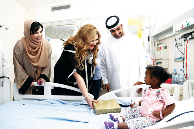"جمعة آل مكتوم ومريم عثمان خلال تقديم الهدايا للمرضى | تصوير: عبد الحنان"