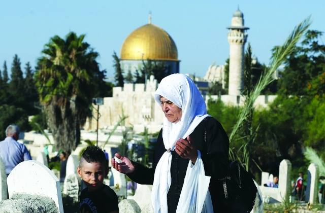 "■ فلسطينية في زيارة إلى قبر أحد الأقارب بالقرب من المسجد الأقصى | أ.ف.ب"