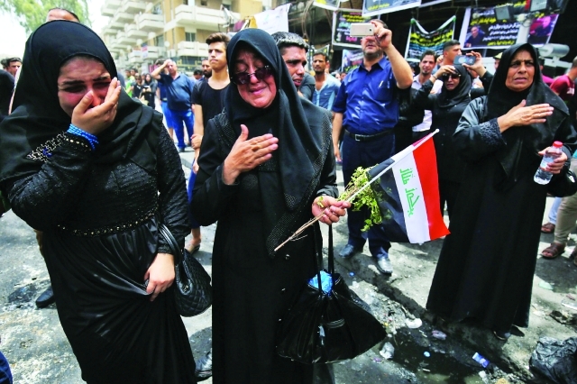"■ عراقيات يبكين في أول أيام العيد حزناً على ضحايا تفجير الكرّادة في بغداد | أ.ف.ب"