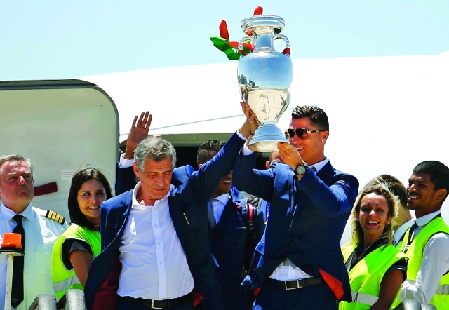 "■ رونالدو يحمل كأس أمم أوروبا إلى جوار سانتوس مدرب البرتغال | رويترز"