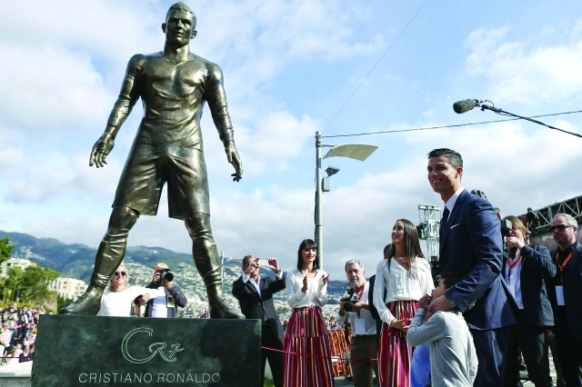 "epa04536874 Portuguese soccer player Cristiano Ronaldo from Real Madrid poses during the unveling ceremony of a statue of himself in his hometown of Funchal, Madeira Island, 21 December 2014. EPA/JOSE SENA GOULAO"