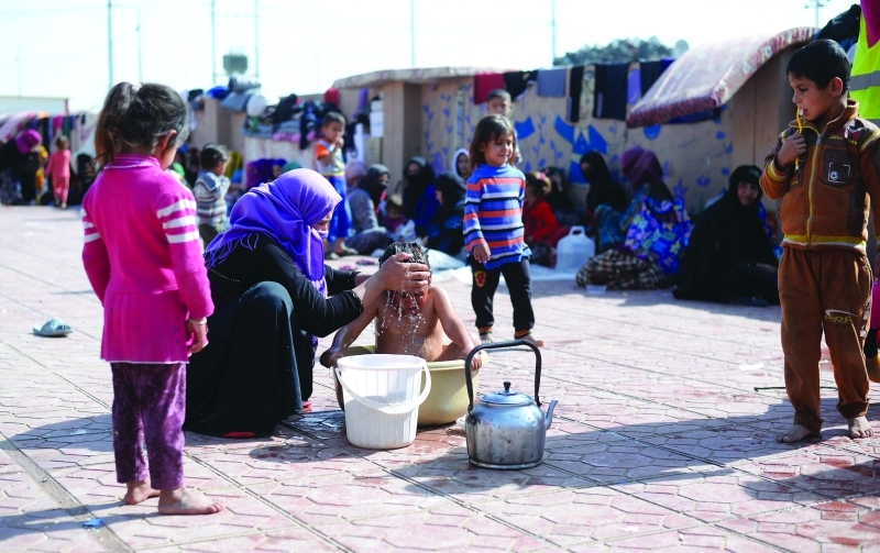 "طفل لاجئ يستحم في حوض من البلاستيك في مخيم بضواحي أربيل | إي.بي.إيه"