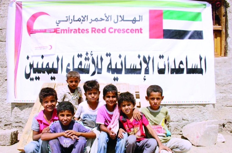 "■ أطفال يمنيون قرب أحد مراكز توزيع السلال الغذائية  |  وام"