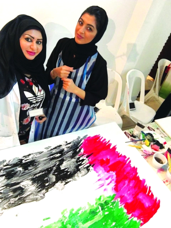 "■ خلود الجابري يسار تشرف على ورشة جدارية العلم"