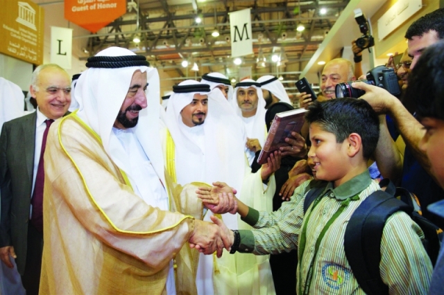 "■ .. ويصافح أحد التلاميذ في المعرض"