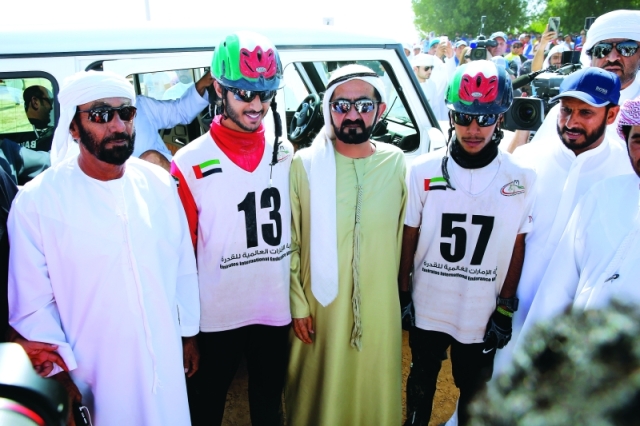 "■ محمد بن راشد يتوسط الفارسين الفائزين بحضور سعيد بن منانة | تصوير: مجدي اسكندر ومرهف العساف"