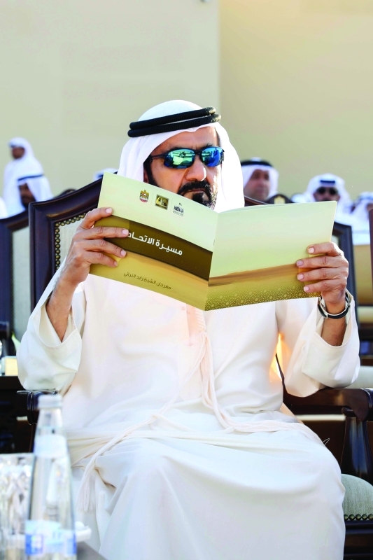 "■ محمد بن راشد مطالعاً مطبوعة خلال المسيرة"