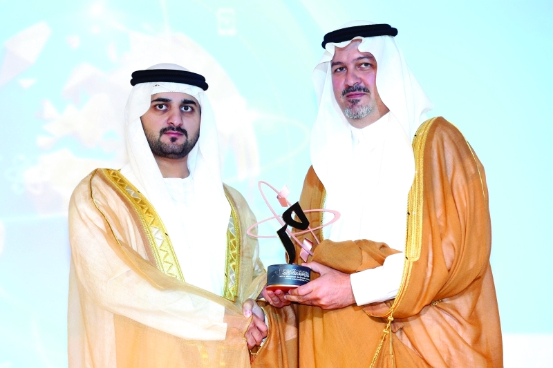 "■ مكتوم بن محمد يقدم الجائزة إلى خالد الفيصل وتسلمها ابنه بندر بن خالد"